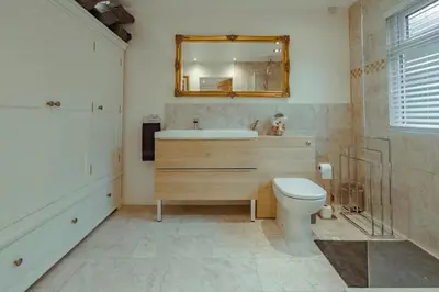 a bathroom with a toilet and a sink and a mirror at Branlea - In the Heart of Ludlow in Ludlow