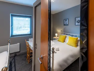 a bedroom with a bed with yellow pillows and a table at Modern flat a short walk from Shrewsbury centre - Pass the Keys in Shrewsbury