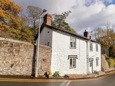 a white building on the side of a street at Wharf Cottage in Llangollen