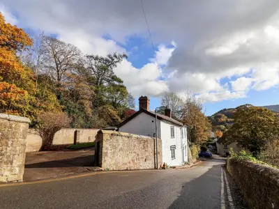 a white house on the side of a road at Wharf Cottage in Llangollen
