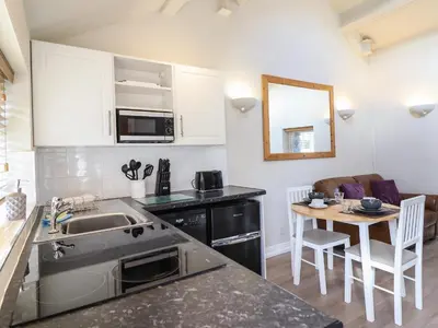 a small kitchen with a sink and a table at Tan Isa in Harlech