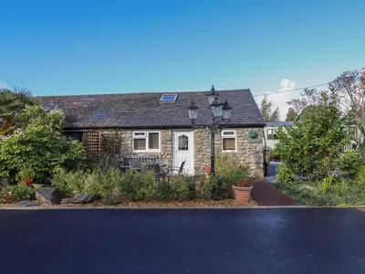 a stone house with a garden in front of it at Tan Isa in Harlech