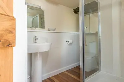 a white bathroom with a sink and a shower at Melin-Byrdir in Dyffryn