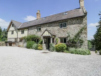 an old stone house with a gravel driveway at Pentre Hall in Oswestry