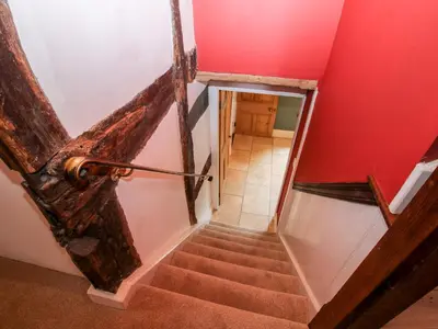 a stairway with an open door and a red wall at Pentre Hall in Oswestry
