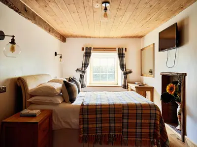 a bedroom with a bed and a window at Bedlwyncoch Farmhouse in Brecon