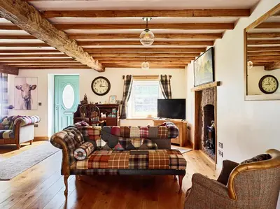a living room with a couch and a fireplace at Bedlwyncoch Farmhouse in Brecon