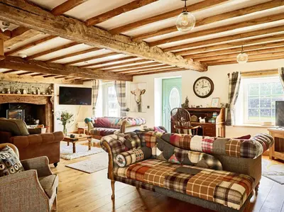 a living room with couches and a fireplace at Bedlwyncoch Farmhouse in Brecon