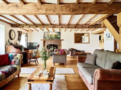 a living room with couches and a fireplace at Bedlwyncoch Farmhouse in Brecon