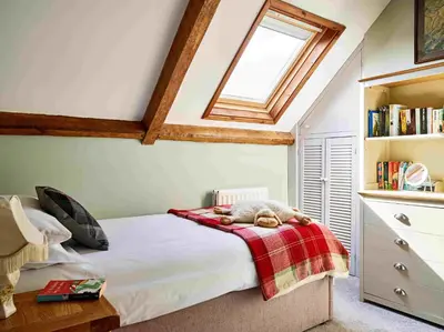 a bedroom with a bed with a teddy bear on a blanket at Llysfaen Cottage in Brecon