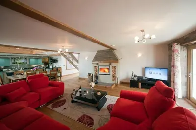 a living room with a red couch and a fireplace at Oak Barn in Brecon