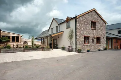 a large brick house with a driveway in front of it at Oak Barn in Brecon