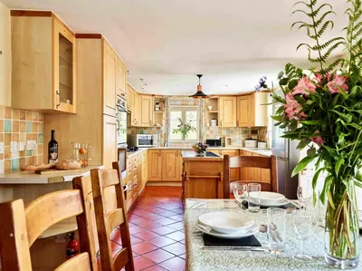 a kitchen with a table with a vase of flowers at Onnen Fawr Farmhouse in Brecon