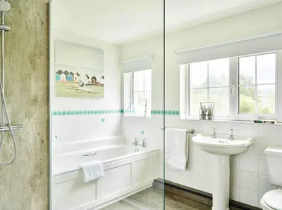 a white bathroom with a tub and a sink at Onnen Fawr Farmhouse in Brecon