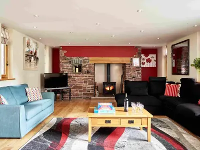 a living room with a couch and a fireplace at Sycamore Tree Barn in Brecon