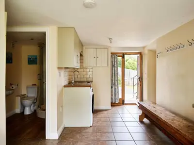 a kitchen with a sink and a toilet and a bench at Sycamore Tree Barn in Brecon