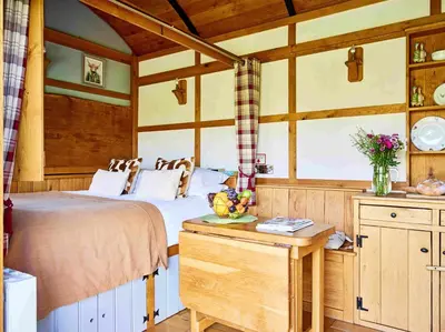 a bedroom with a bed and a table in a room at The Flying Scotsman Shepherd's Hut with Hot Tub in Brecon