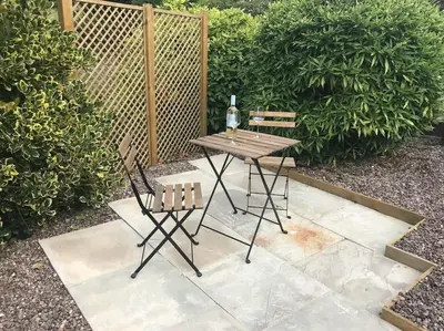 a picnic table and two chairs on a patio at Ty Twty, Montgomery Cottage in Montgomery