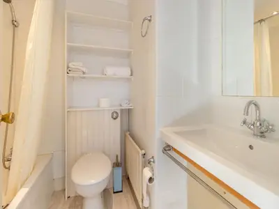 a white bathroom with a toilet and a sink at Morlais in Llanon