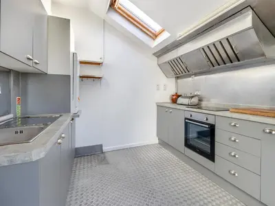 a kitchen with white cabinets and a sink at Morlais in Llanon