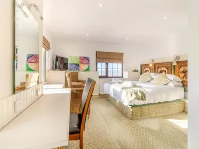 a bedroom with a large bed and a dining room at Morlais in Llanon