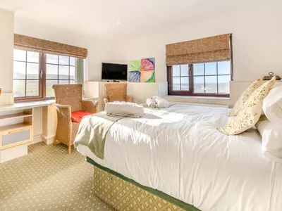 a bedroom with a large white bed and a desk at Morlais in Llanon