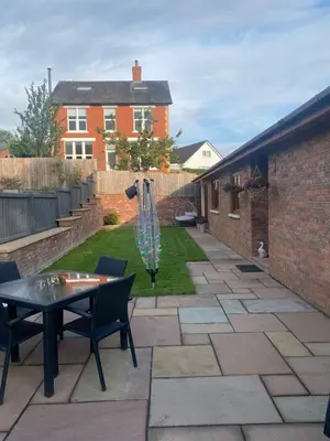 a patio with a table and chairs in a yard at Dave & Kelz Deluxe king size studio room in Builth Wells