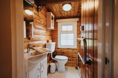 a bathroom with a toilet and a sink and a window at Rustic Log Cabin in Snowdonia - 2 Bedrooms & Parking in Ffestiniog