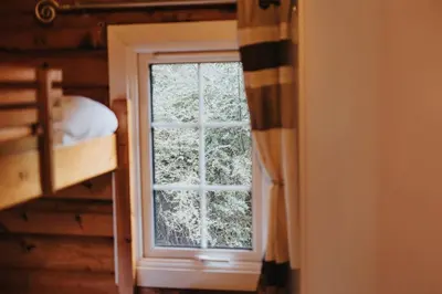 a window in a room with a bed and a bedroom at Rustic Log Cabin in Snowdonia - 2 Bedrooms & Parking in Ffestiniog