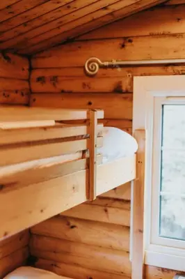 a bunk bed in a wooden cabin with a window at Rustic Log Cabin in Snowdonia - 2 Bedrooms & Parking in Ffestiniog