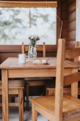 a wooden table with a vase of flowers and a table and chairs at Rustic Log Cabin in Snowdonia - 2 Bedrooms & Parking in Ffestiniog