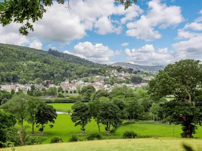 a green field with trees and a town in the distance at 4 Bed in Corwen oc-88868 in Corwen
