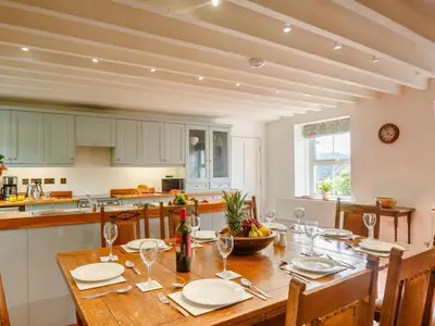 a kitchen with a wooden table and a dining room at 4 Bed in Corwen oc-88868 in Corwen