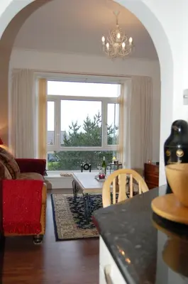 a living room with a table and a couch and a window at Beach Vista Apartment One in Barmouth in Barmouth