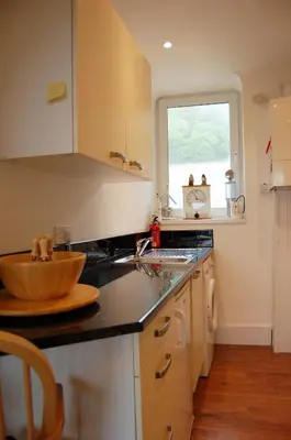 a kitchen with a wooden bowl on the counter at Beach Vista Apartment One in Barmouth in Barmouth