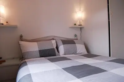 a bedroom with a black and white bed with two pillows at Bryniau Gwyrdd Chalet 11 Happy Valley in Tywyn