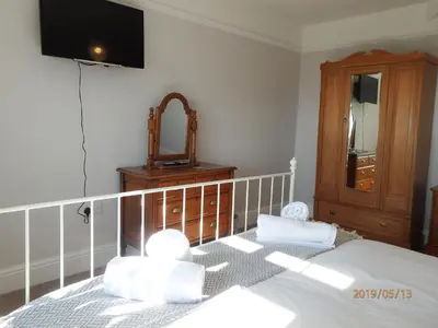 a bedroom with a bed with a mirror and a dresser at Bryn Mair in Barmouth in Barmouth