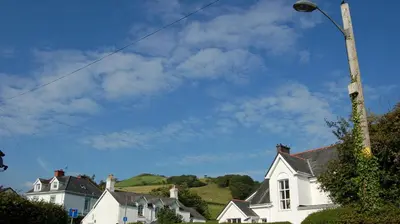 a group of houses and a street light with a blue sky at Bronhaul Cottage in Pennal in Pennal