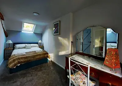 a bedroom with a bed and a large mirror at Cae Tudur Remote Rural Cottage near Barmouth in Barmouth