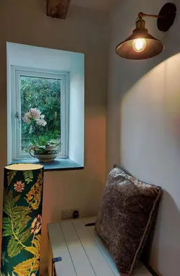 a lamp and a pillow in a room with a window at Cae Tudur Remote Rural Cottage near Barmouth in Barmouth