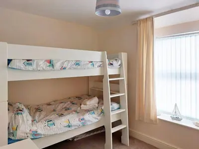 a bedroom with two bunk beds and a window at Hafan Y Traeth Beach Front Apartment in Barmouth in Barmouth