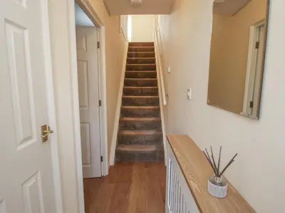 a hallway with stairs and a mirror on the wall at Ludlow House in Ludlow