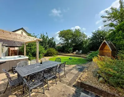 a patio with a table and chairs and a barn at Ty Capel in Tywyn in Tywyn