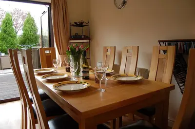 a wooden table with plates and glasses on it at Ty Pen y Bryn in Dolgellau in Dolgellau