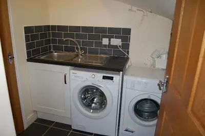 a small kitchen with a sink and a washing machine at Ty Pen y Bryn in Dolgellau in Dolgellau