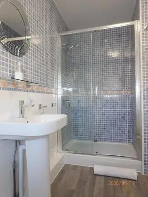 a bathroom with a shower and a sink and a tub at Tywyn Beach House in Tywyn
