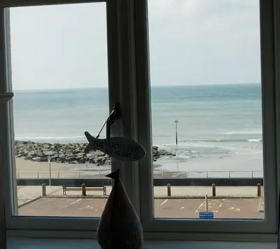 a window with a view of the beach at Sunset Bay Beach House in Tywyn in Tywyn