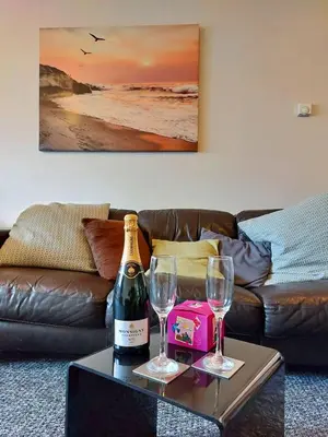 a bottle of wine and two glasses on a table at Swn Y Tonnau in Tywyn