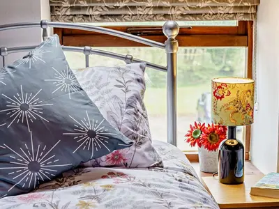 a bed with pillows and a lamp on a table at 2 Bed in Llanybydder oc-81353 in Llanwenog