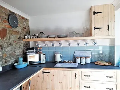 a kitchen with blue tiles and a counter with a microwave at 2 Bed in Llanybydder oc-81353 in Llanwenog